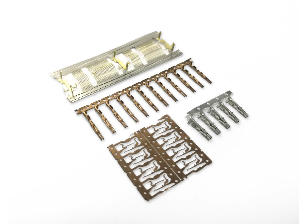 Terminal stamping of connector contacts on carrier strips from a progressive die
