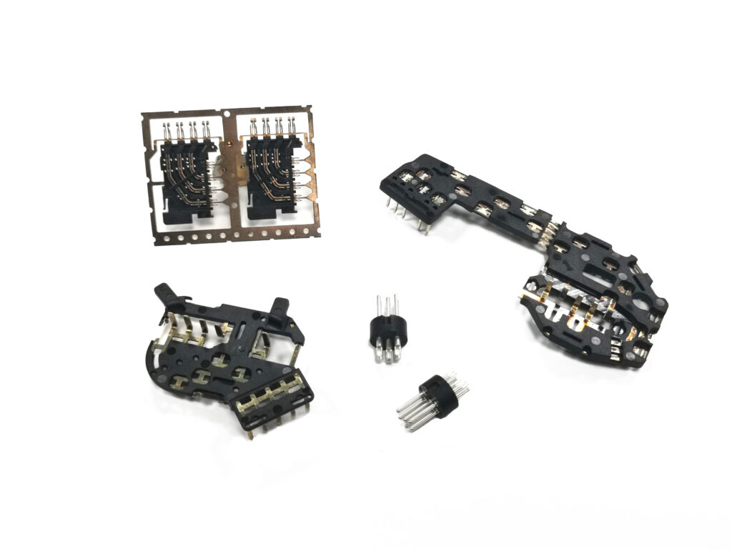 Insert molding parts with metal terminals locked into plastic housings