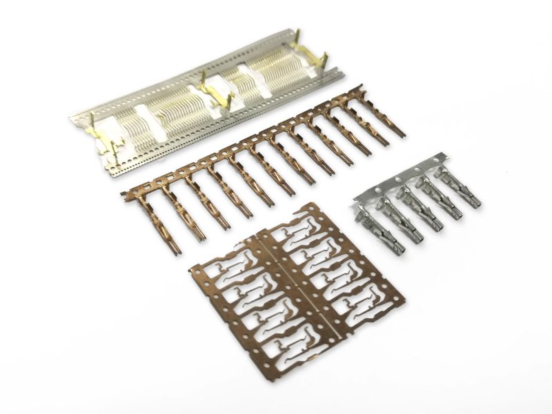 Custom stamped terminals and connector contacts on carrier strips from SSP high-speed stamping dies